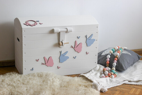 Duży biały kufer na zabawki do dziecinnego pokoju. Klasyczny biały kolor, ozdobiony z zewnątrz pastelowymi motylami. Piękny do pokoju dziewczynek.