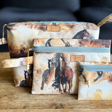 Zdjęcie trzech kosmetyczek w wzór koni, dostępnych w różnych rozmiarach. Kosmetyczki wykonane są z wodoodpornego materiału, idealne na podróże i codzienne użycie.